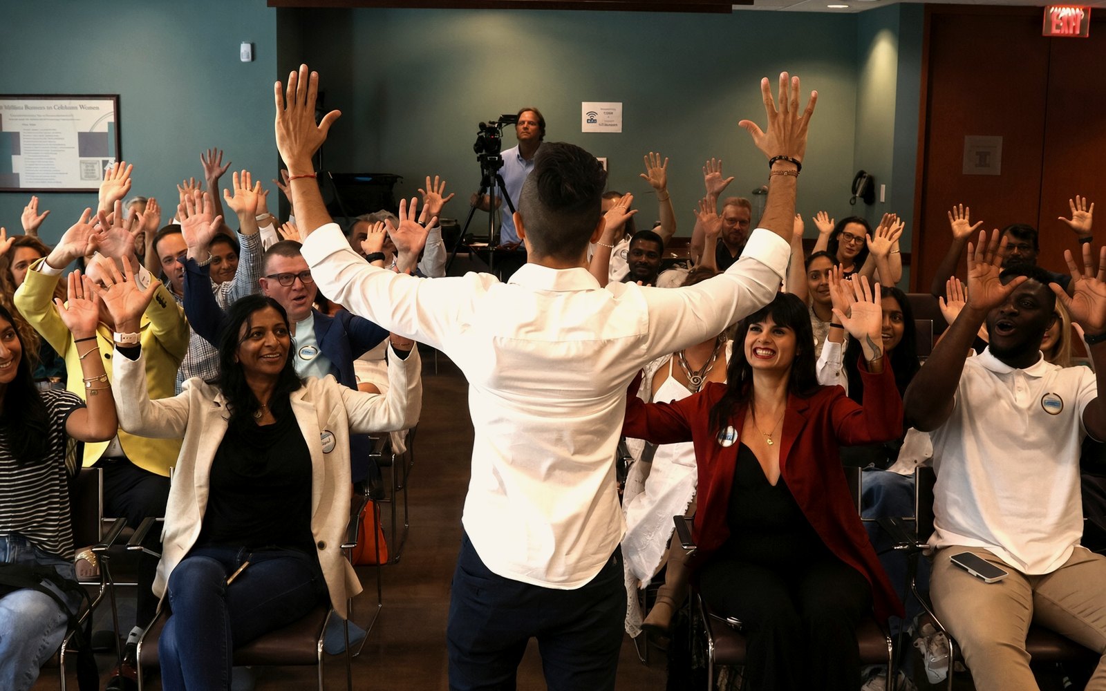 Cal Amir facing a full room with every hand raised